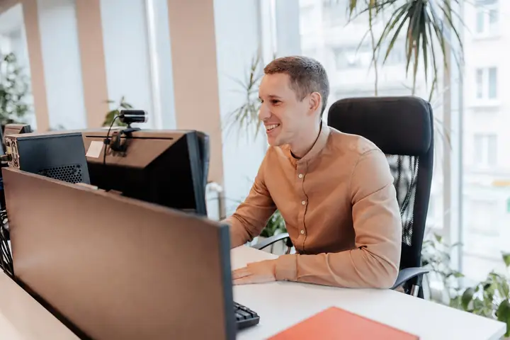 Coleg Simply Contact zâmbind la biroul de lângă fereastră